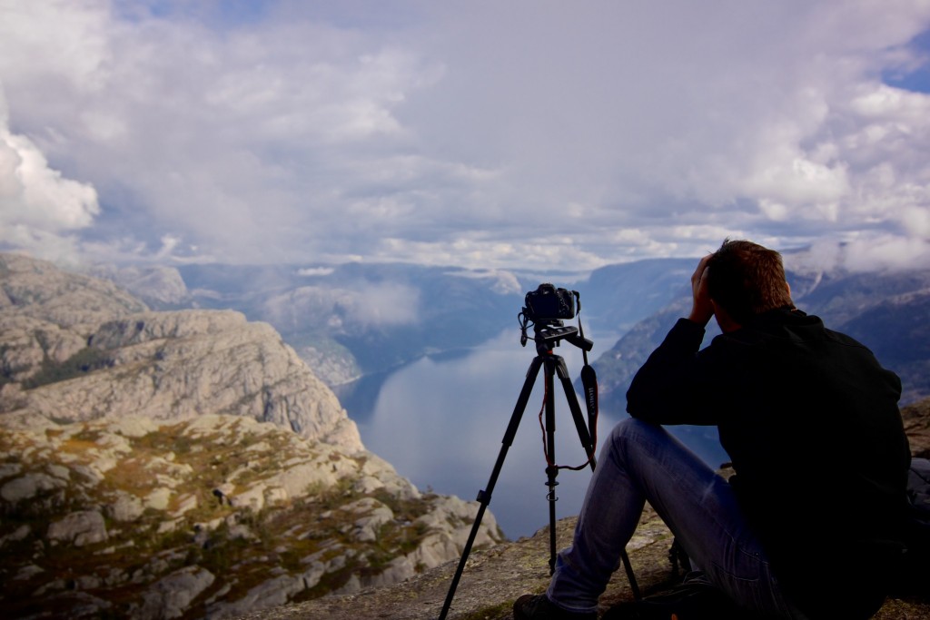 Overzicht van fotograaf op randje Preikestolen en lysefjord in Rogaland Noorwegen.